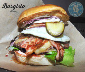 The Australian – Wagyu beef, fried egg, beetroot, turkey bacon, Applewood smoked cheese and onion marmalade, sauce, lettuce, tomato and gherkin in a brioche bun.